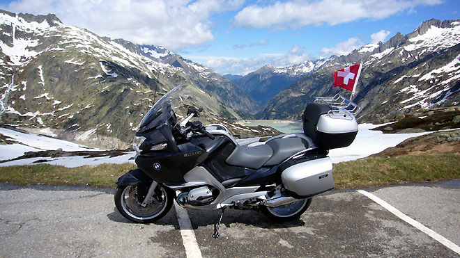Grimselpass, meine RT mit silbernen Koffern und Fahne, im Hintergrund Stauseen