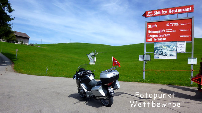 Plakat Skilift markiert die Passhöhe, Fotopunkt Wettbewerbe. Die Passhöhe ist etwas weiter rechts oben aber nicht markiert
