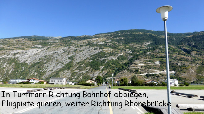Im Dorf Richtung Bahnhof abbbiegen, dann Richtung Rhonebrücke fahren