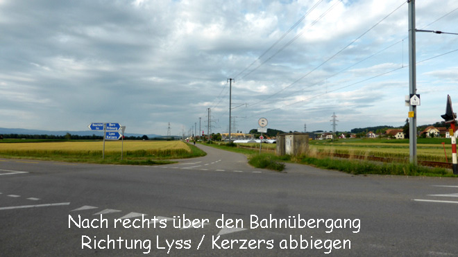 Über den Bahnübergang nach rechts Richtung Lyss / Kerzers fahren