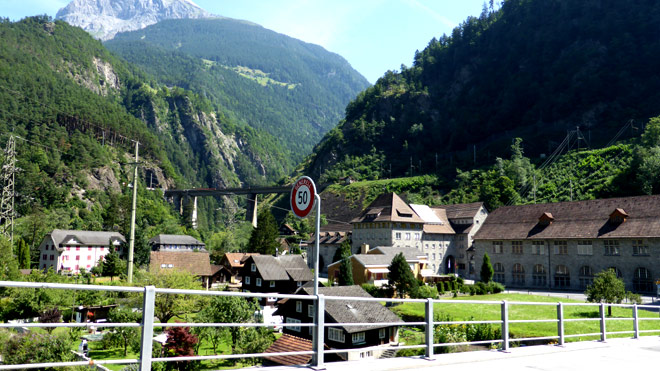 Blick auf Amsteg von der Reussbrücke aus. Sichtbar der Eingang ins Maderanertal, Eisenbahnbrücke, Kraftwerk SBB